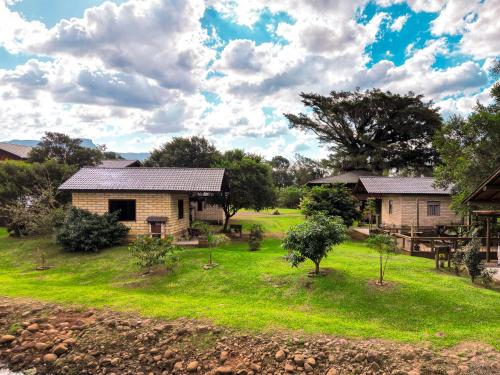 a house in a field with grass and trees at Pousada Equilíbrio dos Canyons in Praia Grande
