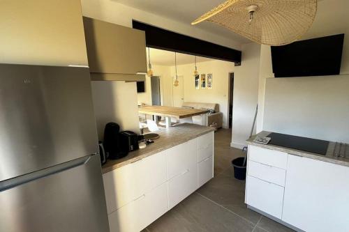 une cuisine avec des armoires blanches et une table en bois dans l'établissement Le Poséidon T2 Vue mer, à Carry-le-Rouet