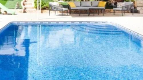 a large blue swimming pool with a table and chairs at Casa Son Juvera Andratx in Andratx