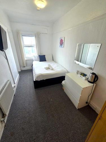 a small room with a bed and a television at Henson hotel in Blackpool