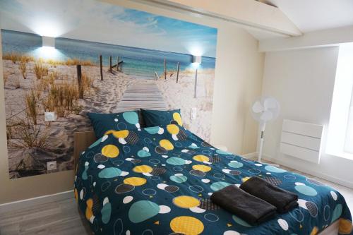 1 dormitorio con 1 cama y una pintura de playa en Maison 2 chambres avec terrasse, en La Roche-sur-Yon