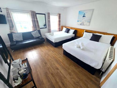 a hotel room with two beds and a chair at Henson hotel in Blackpool