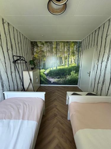 a bedroom with two beds and a wall with trees at Altes Seeblickjuwel in Eutin