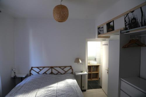 une chambre avec un lit et un mur blanc dans l'établissement Gure Oroitza, à Hendaye