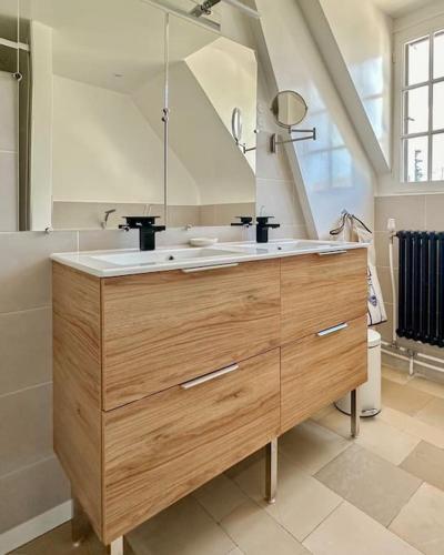 a bathroom with a sink and a large mirror at Le Lampadaire du Martreuil in Pierrefonds