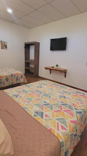 a room with two beds and a flat screen tv at Apartamentos Mundo Maya in Flores