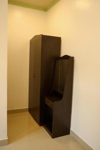 a black refrigerator in a corner of a room at Shifa Lodge Maldives in Feridhoo