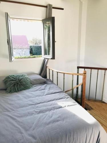 un lit assis dans une pièce avec une fenêtre dans l'établissement Le Colombier, à Le Vaudoué