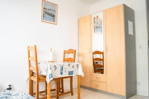a room with a table and chairs and a cabinet at Qhome 1 - Studio entre Paris et Disney in Villiers-sur-Marne