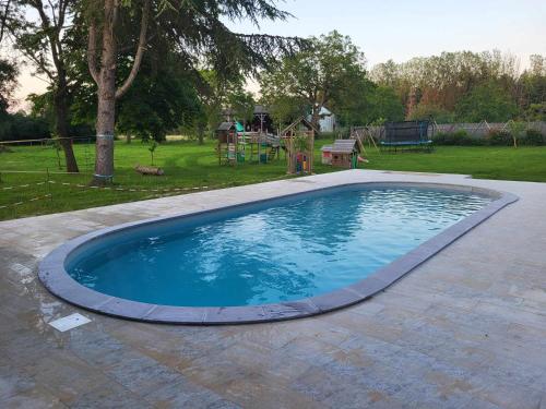a large swimming pool in a yard with a playground at Gîtes sympa, prés du zoo de beauval, "Au Havre de Paix" in Couffy