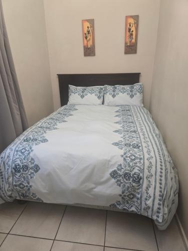 a bedroom with a bed with a blue and white comforter at Three Flags in Pietermaritzburg