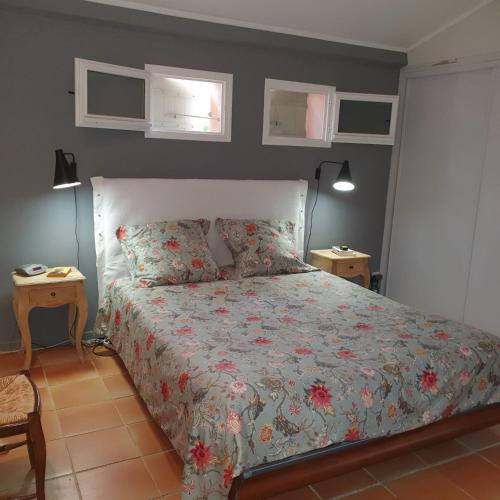 une chambre avec un lit avec un couvre-lit fleuri dans l'établissement les couleurs du sud, à Aix-en-Provence