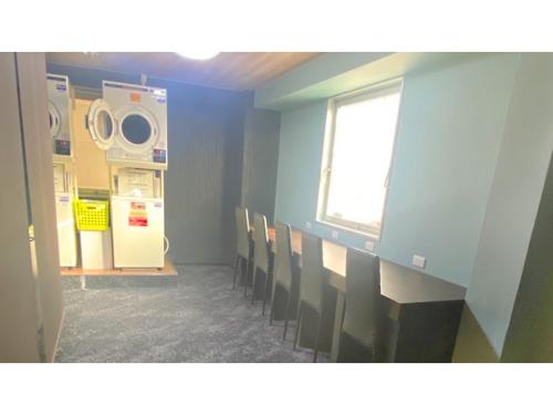 a room with a row of chairs and a washing machine at Takatsuki W&M Hotel - Vacation STAY 48527v in Takatuki