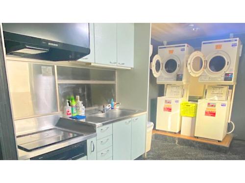 a small kitchen with a sink and a refrigerator at Takatsuki W&M Hotel - Vacation STAY 48527v in Takatuki