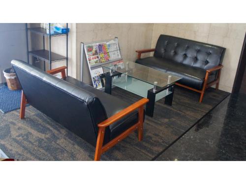a living room with a couch and a glass table at Takatsuki W&M Hotel - Vacation STAY 48527v in Takatuki