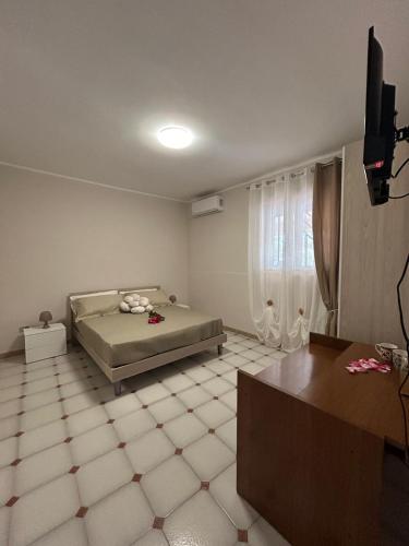 a bedroom with a bed and a television in it at Villa Baglio della Fico a 15 minuti dalla valle dei templi e dal mare in Racalmuto