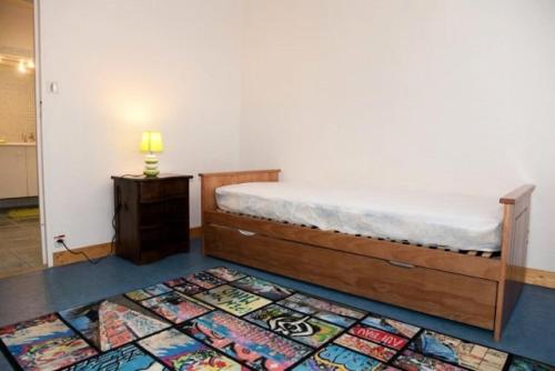 une chambre avec un lit et un tapis au sol dans l'établissement Résidence Casino - Charmant T3 en plein cœur de la station balnéaire du Val-André. MAE-5891, à Pléneuf-Val-André