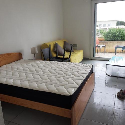 Ce lit se trouve dans un dortoir doté de chaises et d'une fenêtre. dans l'établissement Studio les minimes, à La Rochelle