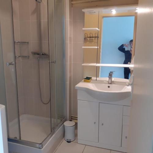 une personne prenant une photo d'une salle de bains avec lavabo et douche dans l'établissement Studio les minimes, à La Rochelle