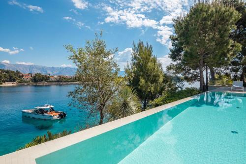 a swimming pool with a boat in the water at Villa Mila in Selca