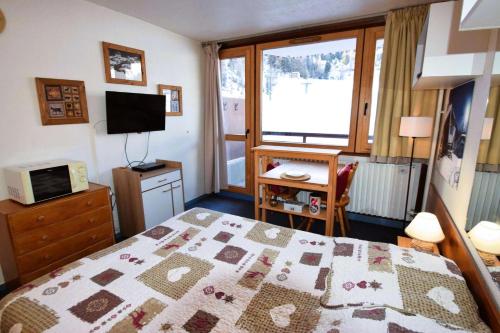 une chambre avec un lit, un bureau et une fenêtre dans l'établissement Résidence Le France - Studio 2 pers - LE FRANCE - PLAGNE CENTRE MAE-5904, à Aime La Plagne