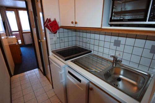 une cuisine avec un évier et un micro-ondes dans l'établissement Résidence Le France - Studio 2 pers - LE FRANCE - PLAGNE CENTRE MAE-5904, à Aime La Plagne
