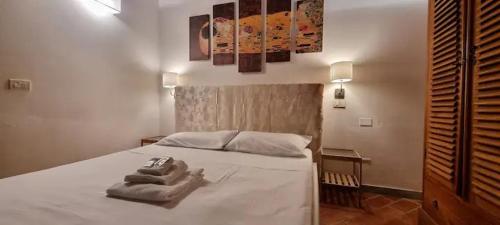 ein Schlafzimmer mit einem weißen Bett mit Handtüchern darauf in der Unterkunft Toscanella23 in Florenz