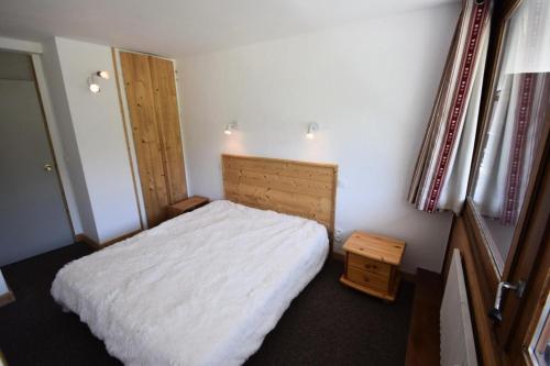 niewielka sypialnia z białym łóżkiem i oknem w obiekcie Résidence Le Mont Blanc - 3 Pièces pour 6 Personnes 024 w Aime La Plagne