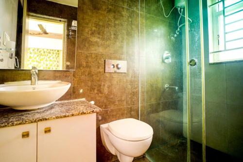a bathroom with a toilet and a sink and a shower at Elite Enclave - Vento - 2BHK Luxury Serviced Apartments in Mysore
