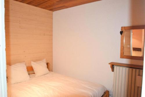Cette petite chambre comprend un lit avec des draps blancs. dans l'établissement Résidence Le Nanda Devi - 2 Pièces 5 pers - LE NANDA DEVI - PLAGNE CENTRE -wifi MAE-8894, à Aime La Plagne