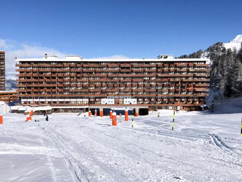 un grand bâtiment dans la neige devant un bâtiment dans l'établissement Résidence Le France - Studio 3 pers - LE FRANCE - PLAGNE CENTRE MAE-9164, à Aime La Plagne