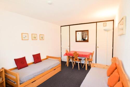 Cette chambre comprend un lit et une table. dans l'établissement Résidence Le France - Studio 3 pers - LE FRANCE - PLAGNE CENTRE - lave-linge MAE-9004, à Aime La Plagne