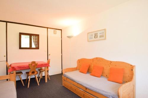 - une chambre avec un lit doté d'oreillers orange et d'une table dans l'établissement Résidence Le France - Studio 3 pers - LE FRANCE - PLAGNE CENTRE - lave-linge MAE-9004, à Aime La Plagne