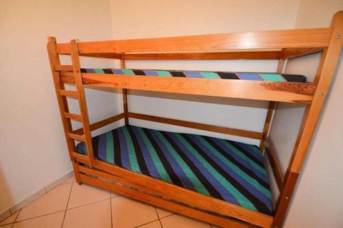 Ce lit superposé en bois se trouve dans un dortoir. dans l'établissement Résidence Le Pelvoux - Studio cabine 4/5 pers - LE PELVOUX - PLAGNE CENTRE MAE-9024, à Aime La Plagne