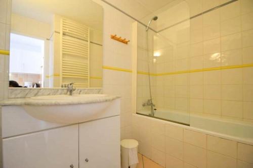 une salle de bain avec un lavabo, un miroir et une baignoire dans l'établissement Résidence Le Pelvoux - Studio cabine 4/5 pers - LE PELVOUX - PLAGNE CENTRE MAE-9024, à Aime La Plagne