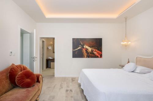 a white bedroom with a bed and a couch at Villa Mila in Selca
