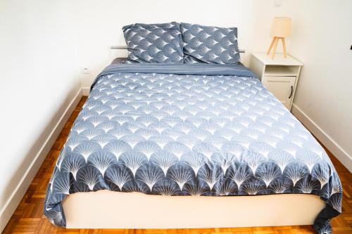 a bedroom with a bed with a blue and white bedspread at Qhome 2 - T2 Cosy entre Paris et Disney - Parking privé in Villiers-sur-Marne