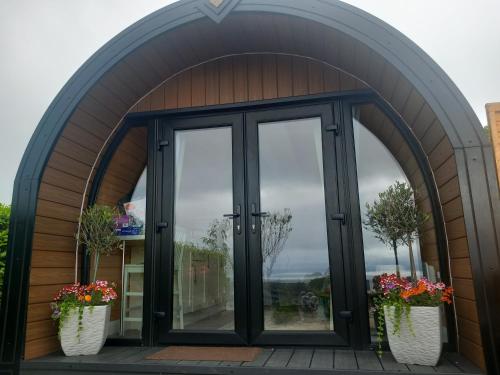 an arched entryway to a house with glass doors at Seaview Glamping Cabin Inishowen in Creehennan