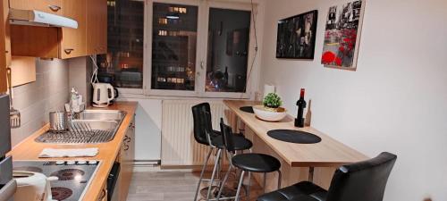 - une petite cuisine avec un comptoir et des chaises dans l'établissement Appartement Lille WIFI Parking by Servallgroup, à Mons-en-Baroeul
