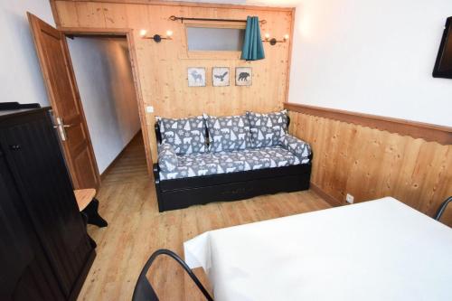 une chambre avec un canapé dans une chambre avec une porte dans l'établissement Résidence Le France - Studio 3/4 pers - LE FRANCE - PLAGNE CENTRE MAE-9414, à Aime La Plagne