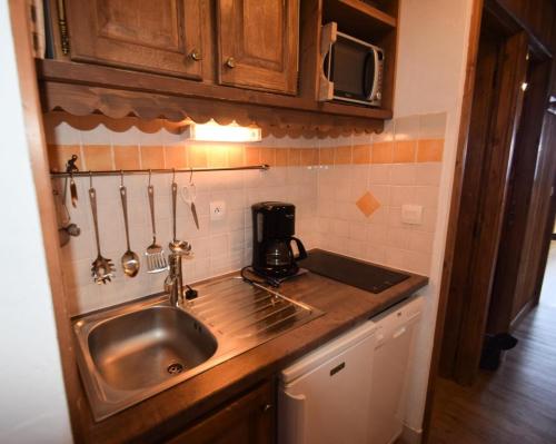 Il comprend une cuisine équipée d'un évier et d'une cafetière. dans l'établissement Résidence Le France - Studio 3/4 pers - LE FRANCE - PLAGNE CENTRE MAE-9414, à Aime La Plagne