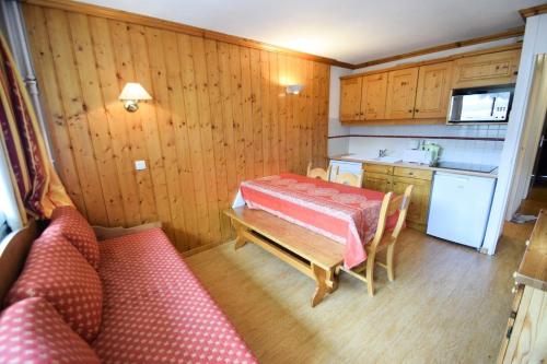 - une cuisine avec une table et un canapé dans une chambre dans l'établissement Résidence Le France - 3 Pièces 6/7 pers - LE FRANCE - PLAGNE CENTRE MAE-9494, à Aime La Plagne