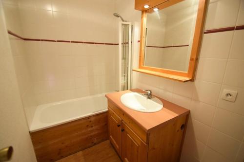 une salle de bain avec un lavabo et une baignoire dans l'établissement Résidence Le France - 3 Pièces 6/7 pers - LE FRANCE - PLAGNE CENTRE MAE-9494, à Aime La Plagne