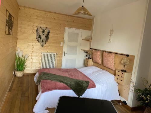 a bedroom with a bed and a wooden wall at La pautière in Saint-Sauveur-Lendelin