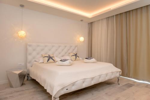 a bedroom with a large white bed with two pillows at Villa Mila in Selca