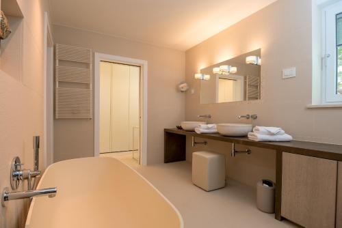 a bathroom with a tub and two sinks and a mirror at Villa Mila in Selca