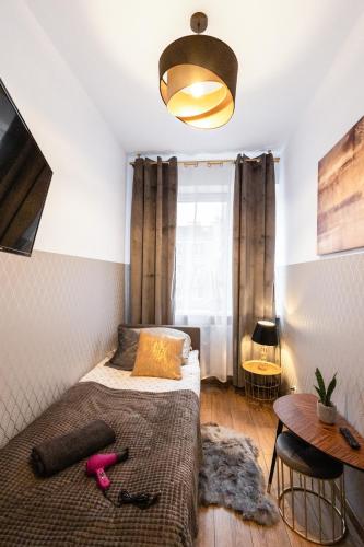 a small bedroom with a bed and a table at ClickTheFlat Żurawia Street Apart Rooms in Warsaw