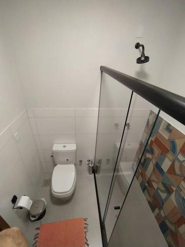 a small bathroom with a toilet and a sink at Studio Ametista na praia do Silveira em Garopaba in Garopaba