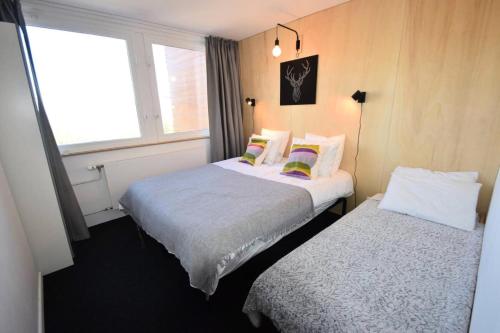 deux lits dans une petite pièce avec une fenêtre dans l'établissement Résidence L'everest - 2 Pièces 5 pers - L'EVEREST - PLAGNE CENTRE MAE-9504, à Aime La Plagne