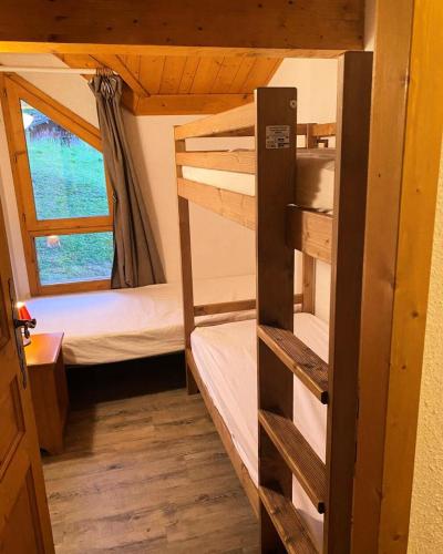 une chambre avec deux lits superposés et une fenêtre dans l'établissement Les Chalets Des Alpages - Chalet 8/10 pers - LES ALPAGES - PLAGNE SOLEIL - WIFI MAE-3534, à Aime La Plagne